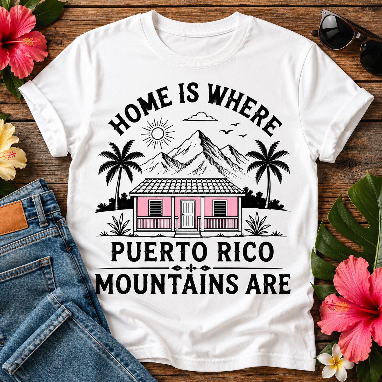 Puerto Rico Mountains T-Shirt featuring a pink island home, tropical palm trees, mountain landscape, and the quote "Home Is Where Puerto Rico Mountains Are"